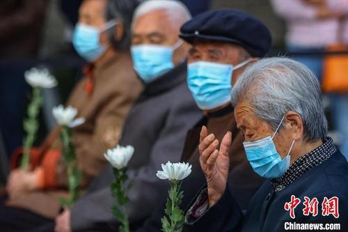 南京大屠杀幸存者艾义英:当时我紧紧抱住爸爸的腿,哭着说不要走(图1) 中国侨网艾义英(右)参加南京大屠杀死难者家庭祭告活动。 泱波 摄
